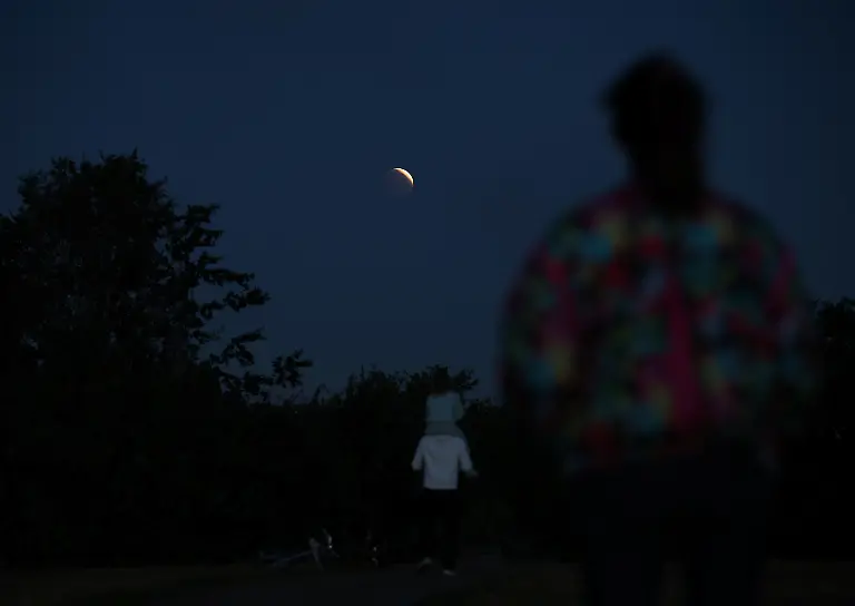 epi_1065810803_REUTERSFOTO_2026-08-28T052637Z 485560233 RC2H7NA34OMK RTRMADP 3 LUNAR-ECLIPSE-BRITAIN.JPG_People watch the par